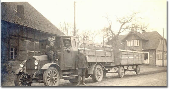 a long, truck and wagon parked on a street in Cardston in the early 1900's