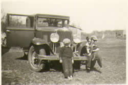 Children playing around old car.  Private collection of Jim Bedson.